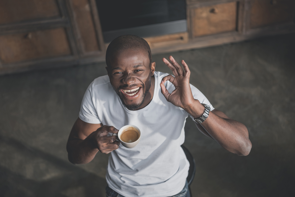 Man laughing while drinking coffee